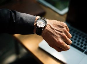 Man looking at watch to make the most of the hours